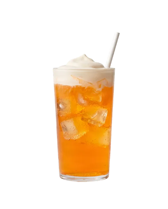 A glass of orange soda over ice with cherry cream on top